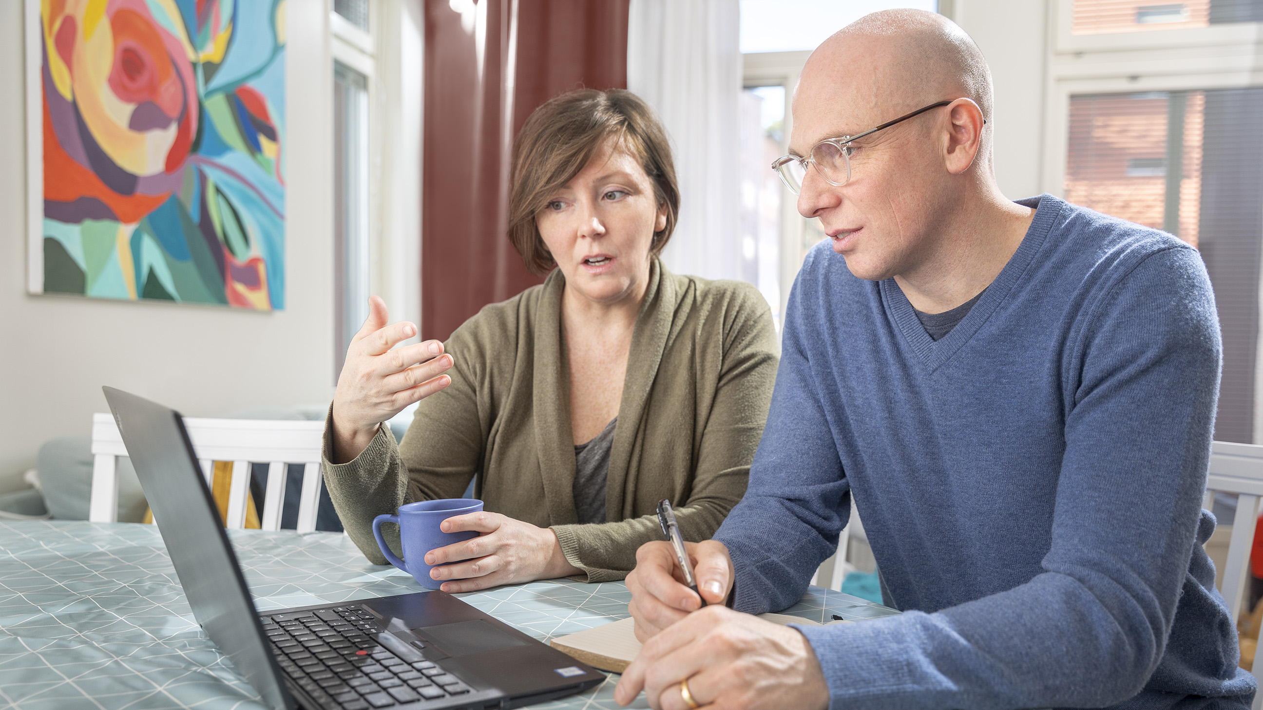 Kvinna och man som sitter vid en laptop