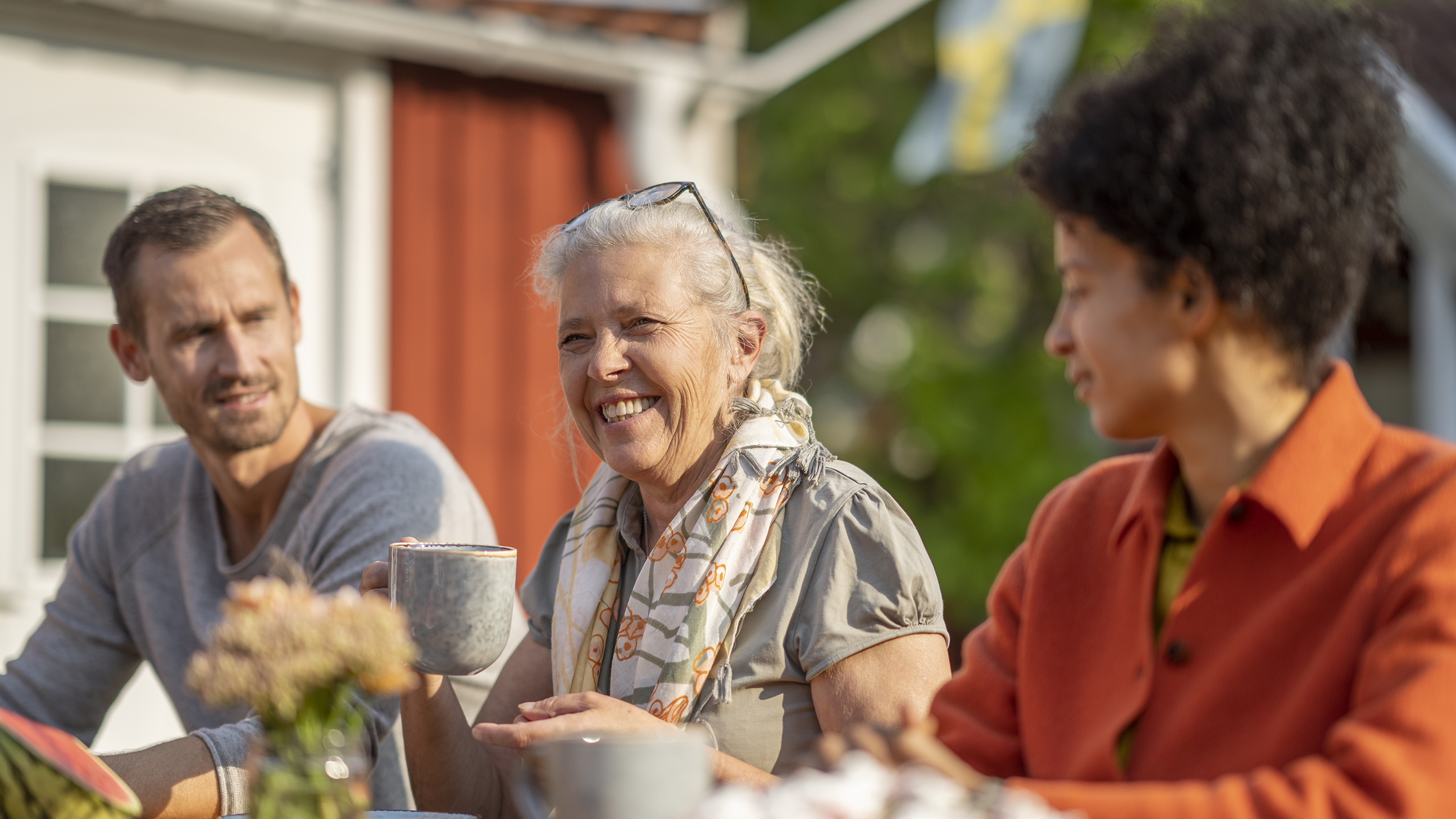 Personer sitter och fikar utomhus.