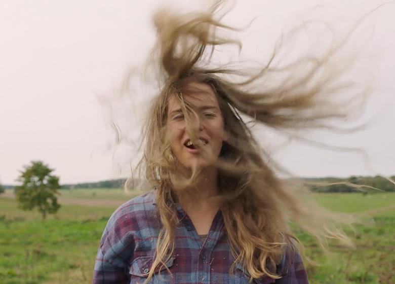 Kvinna med håret som flyger i vinden.