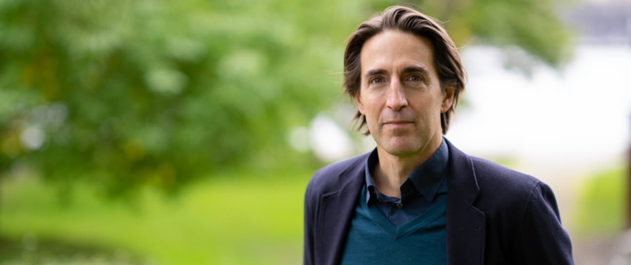 Tomas Flodén tittar in kameran i en somrig utomhusmiljlö
